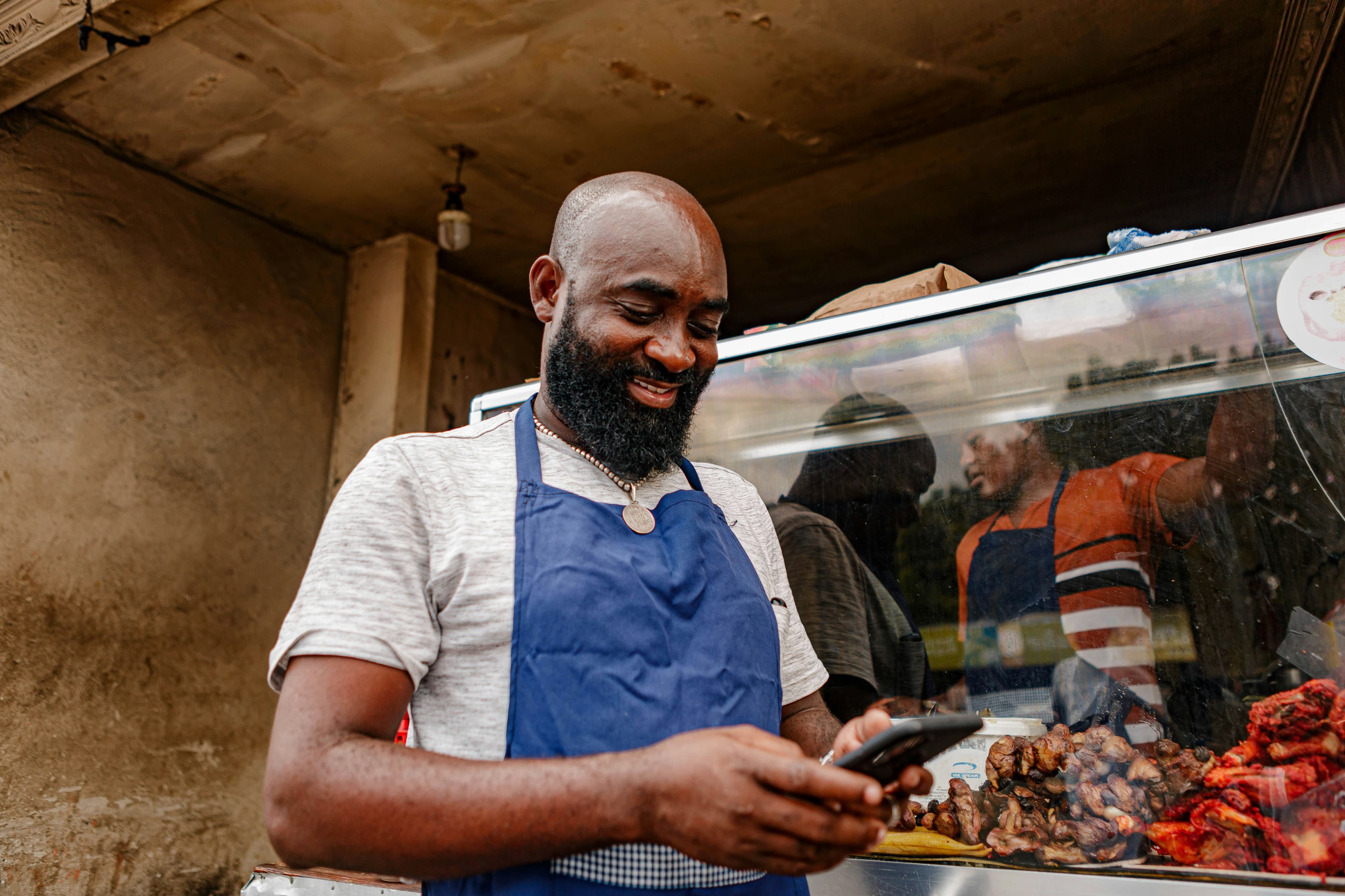 Shop owner checking a payment on his phone